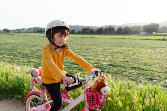 Little girl riding a bicycle in nature 