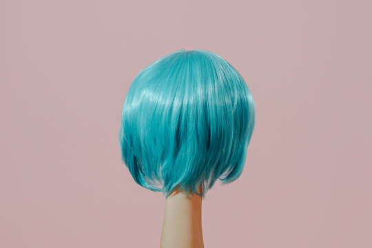 man with a blue wig in his hand