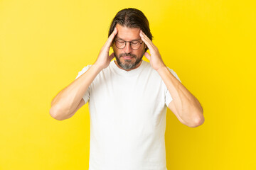 Senior dutch man isolated on yellow background with headache