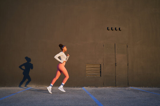 Black woman starting running during training in city