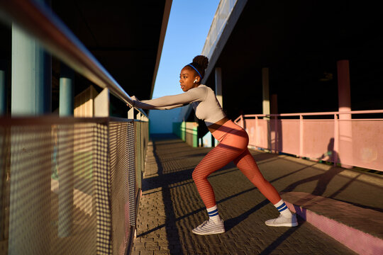 Fit black lady in workout with headphones