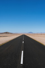 A kilometer long paved straight road in the 
desert of Namibia.