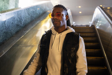 Stylish man is going down the escalator in the metro / sunway