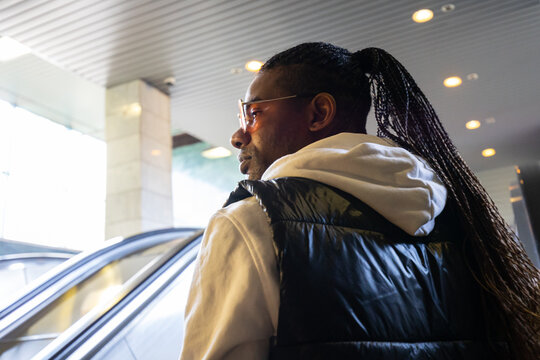 Man seen from behind going up the escalator during the commuting home