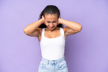 Young woman isolated on purple background frustrated and covering ears
