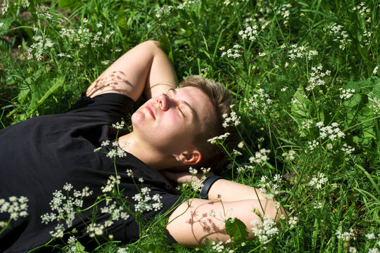 Non Binary person lying in the grass