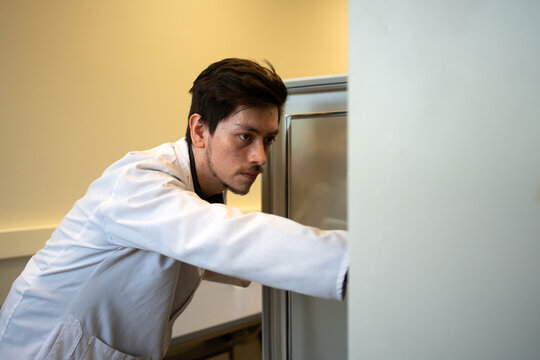 Scientist Opening A Lab Fridge. - Powered by Adobe