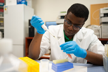 Black Man Scientist Focused Using The Pipette In The Lab.
