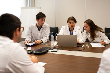 Meeting Of Scientists Discussing Sitting Around The Table.