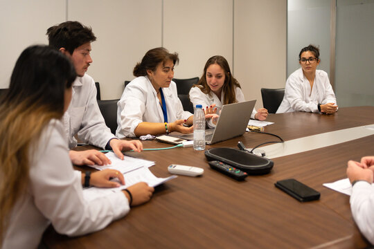 Meeting Of Scientists Discussing Sitting Around The Table.
