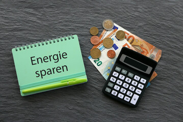 Notizblock mit den deutschen Worten Energie sparen mit Euro Banknoten.