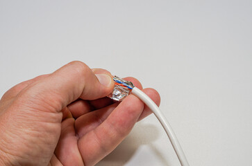 A computer wizard strips the wires of an Internet cable for connecting a twisted pair cable to a...