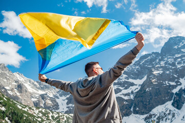 Man with Ukrainian stands on the background of mountains. Morskie Oko