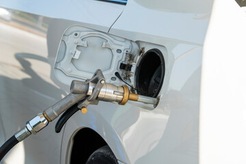 White car at a gas station. The process of refueling a car with liquefied gas