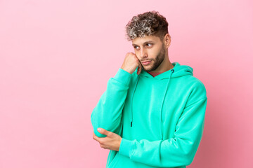 Young handsome caucasian man isolated on pink background with tired and bored expression