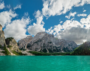 The most famous crystal clear mountain lake at the Dolomites during summer with mountain scenery at the background