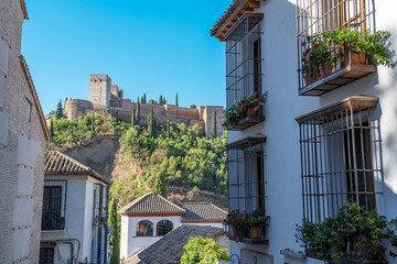 Vista alejada de la Alhambra desde una calle de tradicionales casas blancas de la ciudad de...