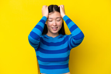 Young Chinese woman isolated on yellow background laughing