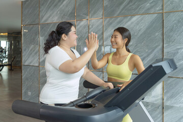 Fat Asian healthy woman, person, running or jogging on treadmill for diet, and training in gym or fitness center in sport and recreation concept. Lifestyle activity. Losing weight with a trainer coach