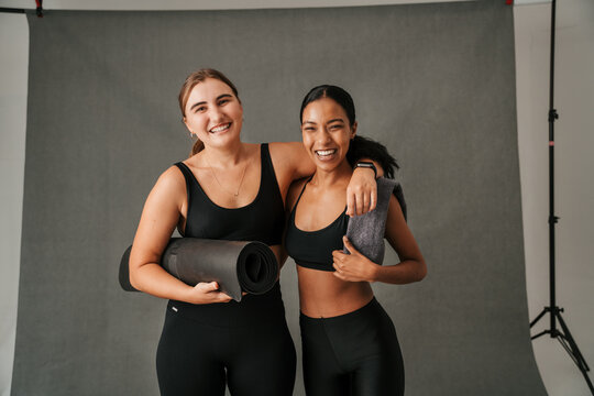 Two Friends Arm In Arm Getting Ready For Yoga Work Out 