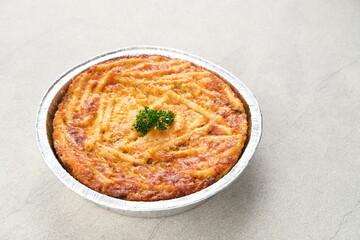 Baked Macaroni Schotel in an aluminium foil cup. Selective focus.
