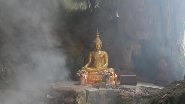 Buddha statue in the cave with fog Thailand