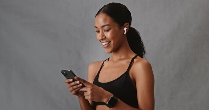 Mixed race female listening with her ear pods on her cellphone 