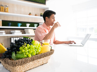 Obraz premium Asian professional manager drinking fresh milk, fruit and nutrition food in the morning while conference meeting with team show productive work at white home
