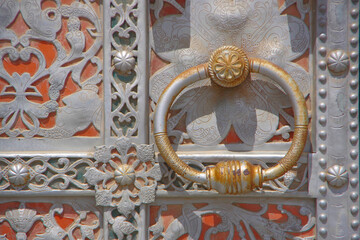 An ancient door with a carved metal pattern and a handle in the form of a ring. Astrakhan, Kremlin.
