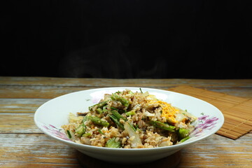 Traditional fried rice mixed with egg and wing beans serving on the plate. Famous street food menu in Thailand. 