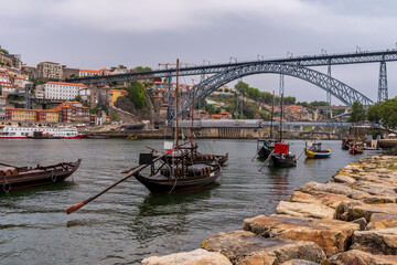 Photo of the old town and the Dom Luis Bridge over the Douro River. Wooden boats in the foreground....