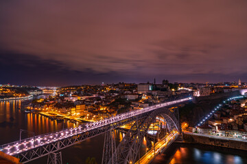 Night photo of the top of the old town and the Dom Luis Bridge over the Douro River. Beautifully illuminatedcity ​​of Porto, Portugal