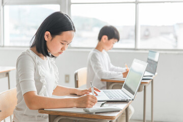 パソコンを使って勉強する日本人の子供（ICT教育・授業・生徒）
