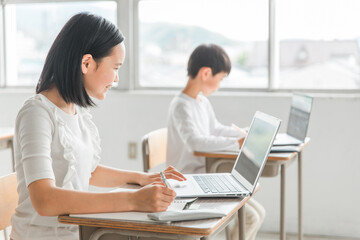 パソコンを使って勉強する日本人の子供（ICT教育・授業・生徒・笑顔）
