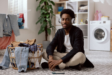 Man with serious face is angry because he has to fold laundry, do household chores, boy doesn't...