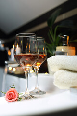 Bathtub with glasses of wine and candles indoors. Romantic atmosphere.