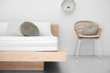 Wooden bed with soft white mattress and pillows indoors