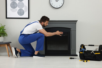 Professional technician installing electric fireplace in room