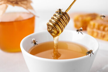 Tasty honey and bees on table, closeup