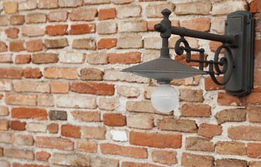 Vintage street lamp on red brick wall of building