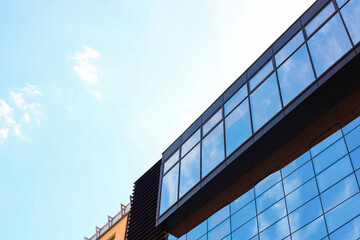 Low angle view of modern building with tinted windows against blue sky
