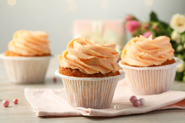 Tasty cupcakes with cream on table, closeup