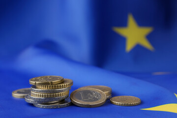Many different coins on European Union flag, space for text