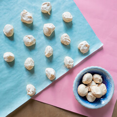 Homemade french milk-colored meringues on blue paper