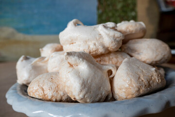 Homemade french milk-colored meringues on crumpled craft paper