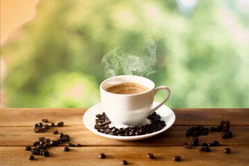 Coffee cup with roasted coffee beans on wooden table. Selective focus.