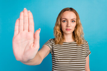 Portrait of strict woman show stop gesture wear casual shirt isolated on blue color background
