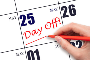 25th day of May. Hand writing text DAY OFF and drawing a line on calendar date 25 May. Vacation...