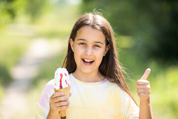 Beautiful little girl eats ice-cream in the summer