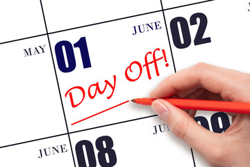 1st day of June. Hand writing text DAY OFF and drawing a line on calendar date 1 June. Vacation planning concept. Summer month, day of the year concept.